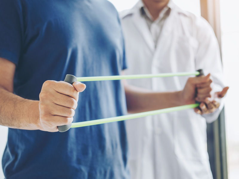 Man using rubberbands to do physical therapy 